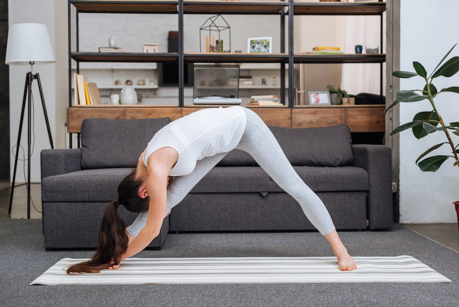 Woman doing a yoga stretch in a living room.